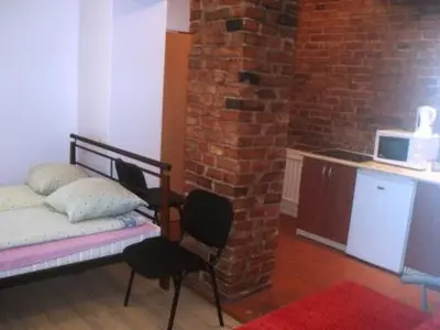 a bedroom with a bed and a brick wall at Kaunas Apartments in Kaunas