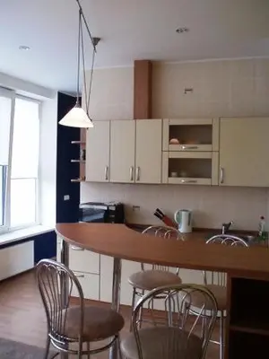 a kitchen with a bar with chairs and a counter at Kaunas Apartments in Kaunas