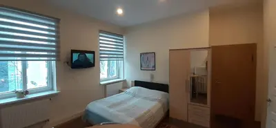 a bedroom with a bed and a tv on the wall at Kaunas Apartments in Kaunas