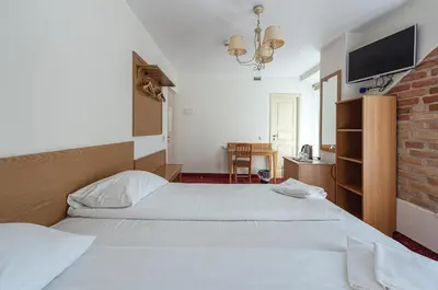 a hotel room with a bed and a television at Alexa Old Town in Vilnius