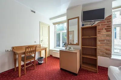 a room with a desk and a table and a tv at Alexa Old Town in Vilnius