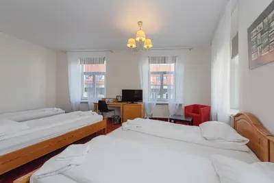 a room with three beds and a desk with a computer at Alexa Old Town in Vilnius