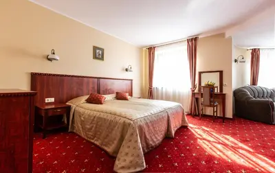 a hotel room with a bed and a chair at Galia in Druskininkai
