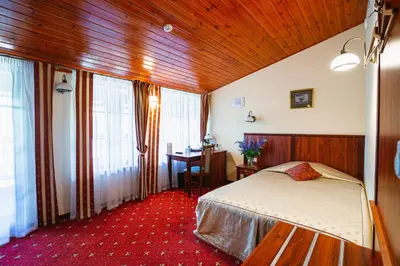 a bedroom with a bed and a table and windows at Galia in Druskininkai