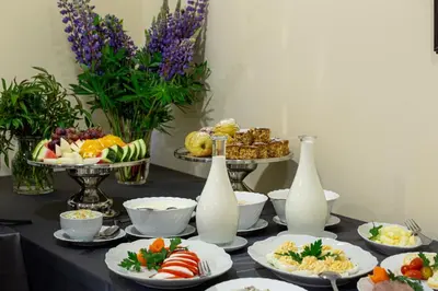 a table with plates of food and bottles of milk at Galia in Druskininkai