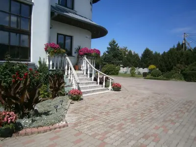 a house with stairs and flowers in front of it at Nemunas Tour Residence in Kaunas