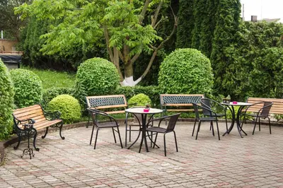 a group of tables and chairs and a table and benches at Nemunas Tour Residence in Kaunas