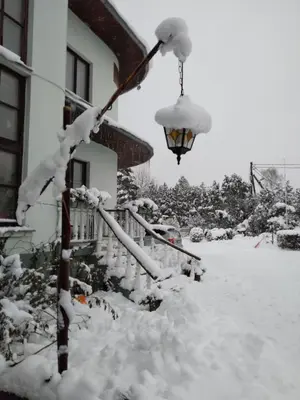 a street light covered in snow next to a house at Nemunas Tour Residence in Kaunas
