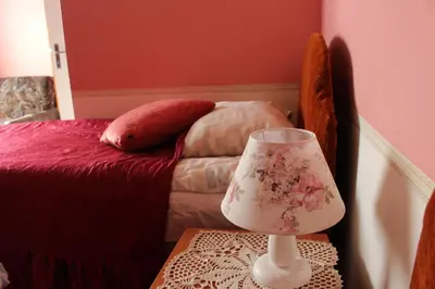 a lamp sitting on a table next to a bed at Nemunas Tour Residence in Kaunas