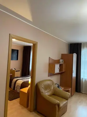 a hotel room with a chair and a bed at Hotel Jerevan in Druskininkai