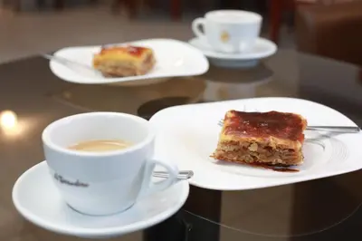 a plate with a piece of cake and a cup of coffee at Hotel Jerevan in Druskininkai