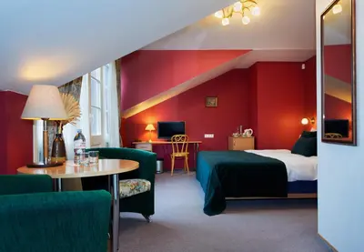 a hotel room with a bed and a table and chairs at Angel Town Hall Apartments in Vilnius