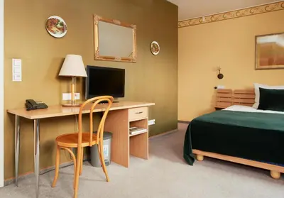 a hotel room with a bed and a desk with a computer at Angel Town Hall Apartments in Vilnius