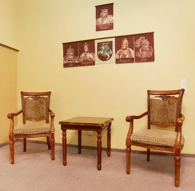 a room with two chairs and a table and a wall with pictures at Angel Town Hall Apartments in Vilnius