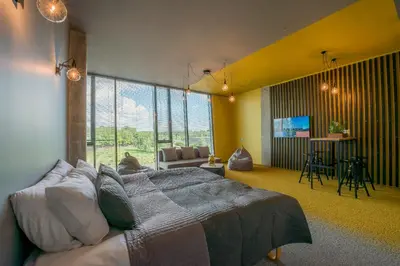 a bedroom with a bed and a living room at Urbihop Hotel in Vilnius