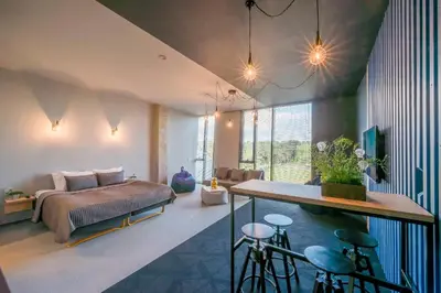 a bedroom with a bed and a table with stools at Urbihop Hotel in Vilnius