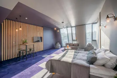 a bedroom with a large bed and a table at Urbihop Hotel in Vilnius
