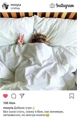 a person sleeping in a bed with white sheets at Urbihop Hotel in Vilnius