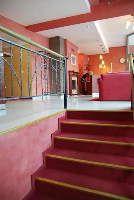 a staircase in a building with a red couch at Hotel Medūna in Druskininkai