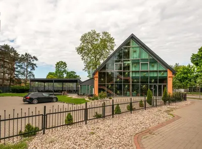 a house with a car parked in front of it at Hotel Medūna in Druskininkai