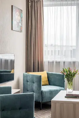 a living room with two blue couches and a window at Hotel Zemaites in Vilnius