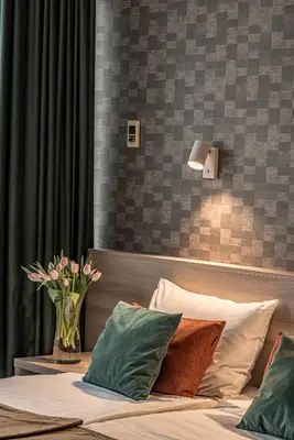 a bedroom with a bed with a vase of flowers on it at Hotel Zemaites in Vilnius