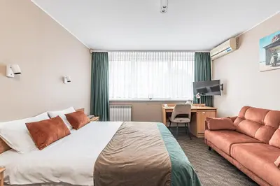 a hotel room with a bed and a couch at Hotel Zemaites in Vilnius
