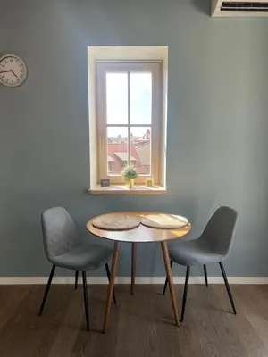 a table and two chairs in a room with a window at Angel House Vilnius 40 in Vilnius