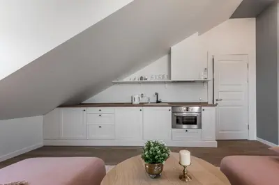 a kitchen with white cabinets and a table at Angel House Vilnius 40 in Vilnius