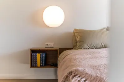 a bedroom with a bed with a lamp and a book shelf at Angel House Vilnius 38A in Vilnius