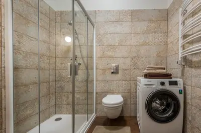 a bathroom with a washing machine and a toilet at Angel House Vilnius 38A in Vilnius