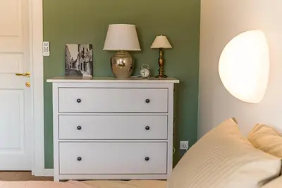 a bedroom with a white dresser with a lamp on it at Angel House Vilnius 38A in Vilnius