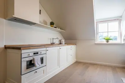 a kitchen with white cabinets and a stove top oven at Angel House Vilnius 38A in Vilnius