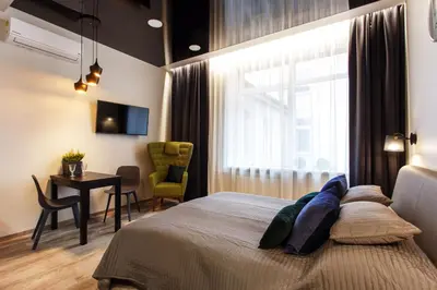 a bedroom with a bed and a desk and a window at Old Town Trio Apartments in Vilnius
