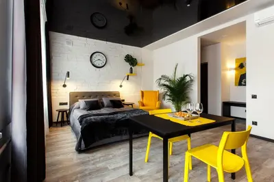 a bedroom with a bed and a table and yellow chairs at Old Town Trio Apartments in Vilnius