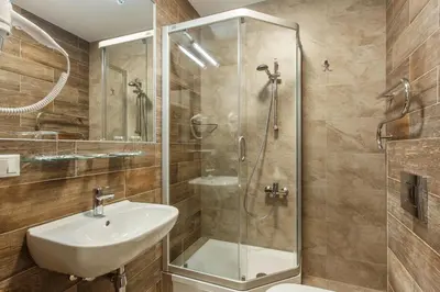 a bathroom with a sink and a glass shower at Old Town Trio Apartments in Vilnius