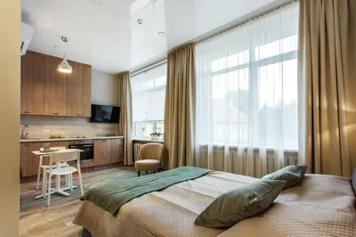 a bedroom with a bed and a desk and a kitchen at Old Town Trio Apartments in Vilnius