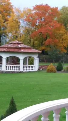 a white gazebo in a field of green grass at Gazdų Vandens Malūnas in Navininkai