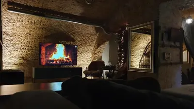 a living room with a tv on a stone wall at Unique Old Town Apartment in Vilnius