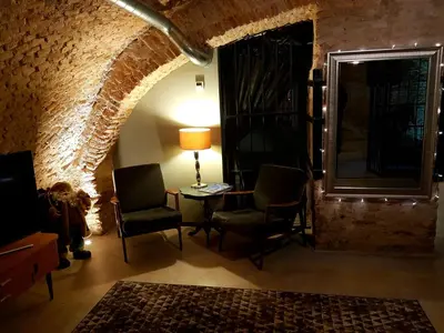 a living room with chairs and a table and a brick wall at Unique Old Town Apartment in Vilnius