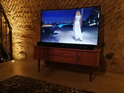 a flat screen tv sitting on a wooden stand with a bride on it at Unique Old Town Apartment in Vilnius