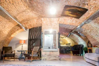 a living room with a brick ceiling and chairs at Unique Old Town Apartment in Vilnius