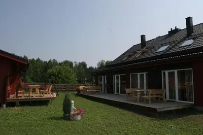 a house with a patio and a table and chairs at Love Island Guesthouse in Druskininkai