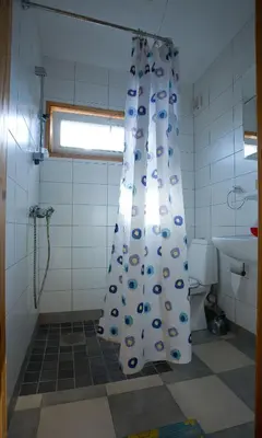 a bathroom with a shower curtain and a toilet at Love Island Guesthouse in Druskininkai