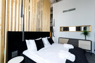 a bedroom with a bed with white sheets and pillows at Loop Hotel Vilnius in Vilnius