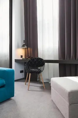 a chair sitting in front of a desk in a room at Loop Hotel Vilnius in Vilnius