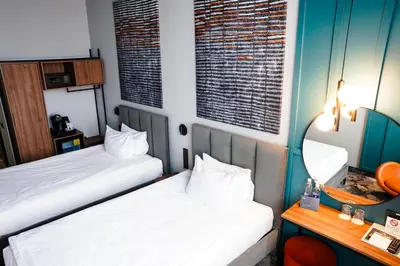 a hotel room with two beds and a mirror at Loop Hotel Vilnius in Vilnius