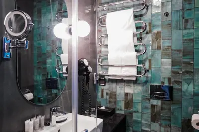 a bathroom with a sink and a mirror and towels at Loop Hotel Vilnius in Vilnius