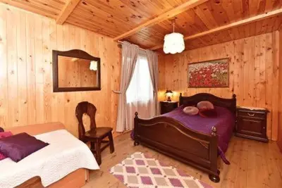 a bedroom with a bed and a chair in a room at Sodyba Sauletekis in Ignalina