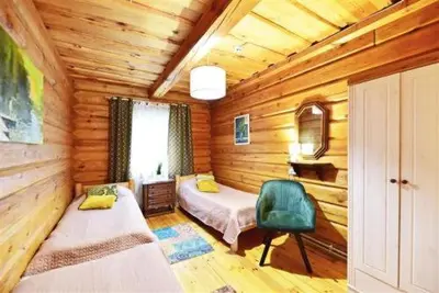 a bedroom with two beds in a wooden cabin at Sodyba Sauletekis in Ignalina